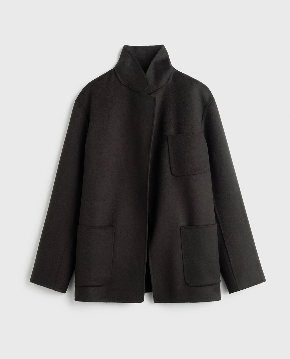 Mørk jakke med boxy snit, standkrave og tre forlommer. Åben front.