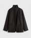 Mørk jakke med boxy snit, standkrave og tre forlommer. Åben front.